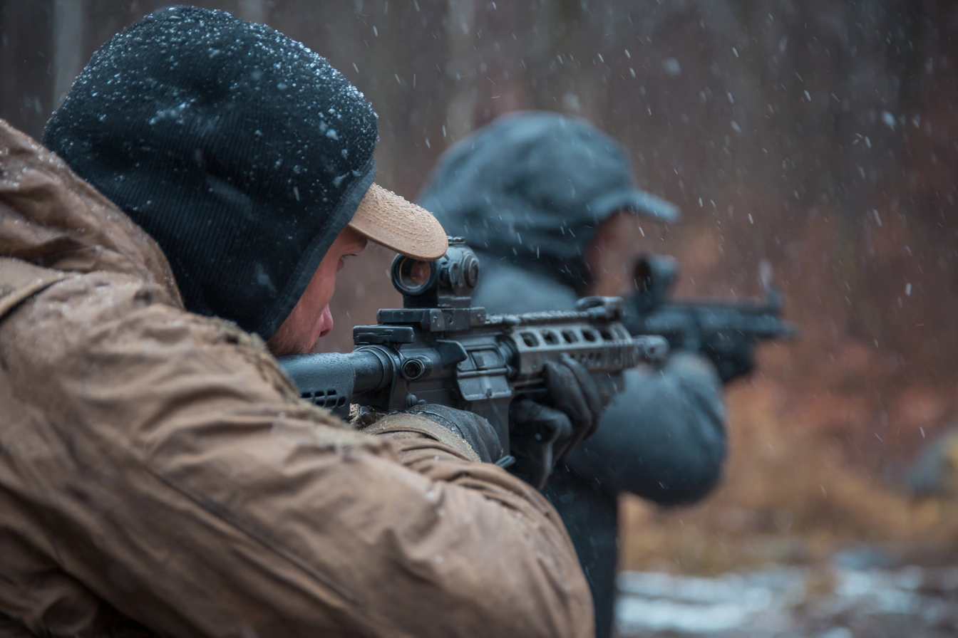 Close protection trainees practicing rifle shooting in adverse weather conditions